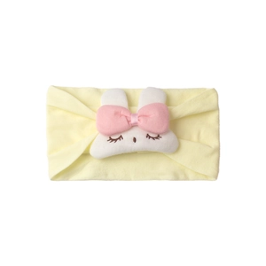Detailed view of yellow baby headband with soft texture and white plush rabbit motif