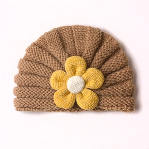 Kaffeebraune Strickmütze für Babys mit einer großen gelben Stoffblume als Dekoration
