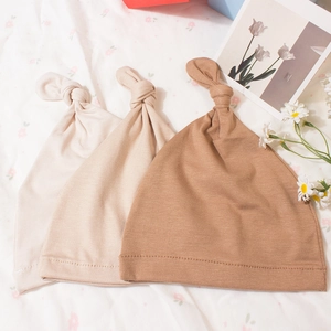 Three-pack of ribbed knit baby knot hats in cream, oatmeal, and light brown colors