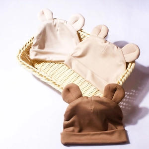 Détail de trois bonnets en modal pour bébé avec oreilles d'ours aux tons terreux