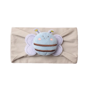 Close-up of baby nylon headband featuring a cute plush bee on soft beige fabric