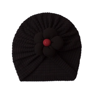 Detail view of baby knot hat with floral decoration and vertical ribbed knit texture