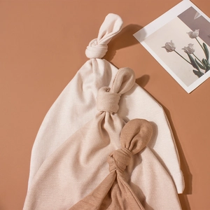 Three-pack of baby top knot hats in earthy neutral tones with ribbed knit texture
