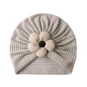 Detailed close-up of grey waffle knit baby turban hat with a yellow floral knot decor