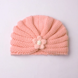 Detail of baby knit turban with handmade floral decoration and ribbed warm texture