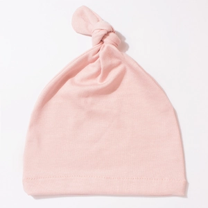 Detail of baby knot hat in soft pink cotton fabric with high-quality stitched edges