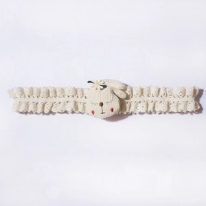 Detail of baby headband with white lace band, plush bunny head and small daisy flower