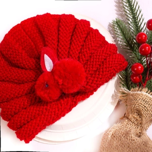 Detailed texture of red knitted baby turban hat with a cute 3D bunny decoration