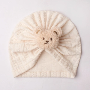 Details von Baby Turban Mütze mit cremefarbener Strickstruktur und Bär-Ornament