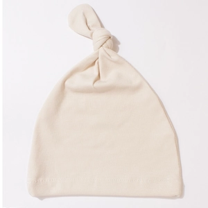 Close-up of beige baby knot hat showing soft knitted cotton fabric and stitch detail