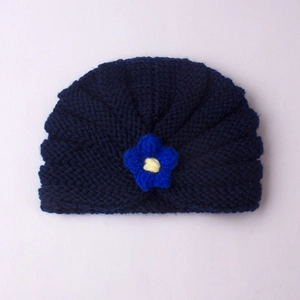 Detail of navy blue knitted baby beanie with handmade floral crochet decorative pattern