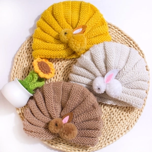 Detailed knit texture of baby turban hats with cute plush bunny decor in three soft colors