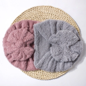 Close-up of soft plush baby beanies in pink and grey colors with knot design detail