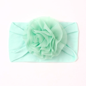 Bandeau bébé en nylon vert menthe doux orné d'une grande fleur en mousseline épaisse