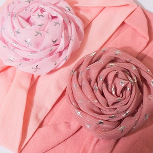 Close-up of pink baby headbands with large fabric roses and silver bird prints