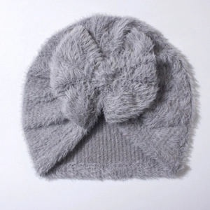 Detail of grey faux fur baby hat featuring a knot design and soft knit ribbed edge