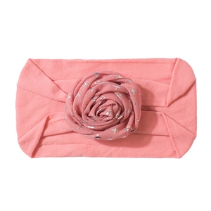 Detail of baby elastic headband with peach pink fabric flower and silver star prints