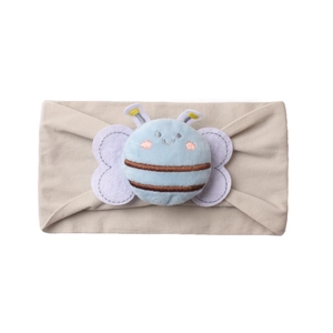 Détail du bandeau bébé avec une abeille en peluche bleue sur tissu beige extensible