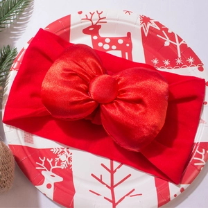 Detailaufnahme einer großen roten Baby-Stirnband-Satinschleife für Weihnachtsfeierlichkeiten