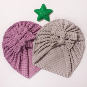 Detail of baby turban hats with large bows in purple and grey waffle knit fabric
