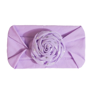Detailed close-up of light purple baby headband with floral ornament and silver stars