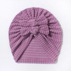 Close-up of purple baby turban hat with double bow design and waffle knit texture