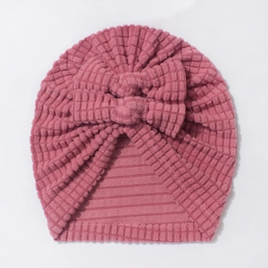 Detailed view of dust pink waffle texture fabric and decorative double bow on baby hat