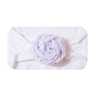 Detailed view of white elastic baby headband with silver star print fabric rose decoration