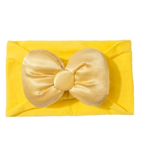 Detail eines weichen gelben Baby-Haarbands mit flauschiger Satinschleife für Kinder