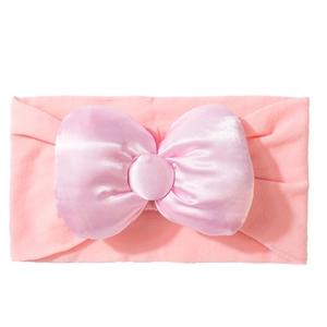 Detail eines rosa Baby Stirnbands mit großer Satin Schleife und elastischem Gewebe