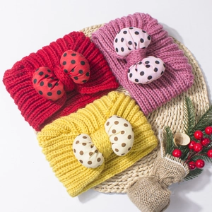 Detail of baby knitted headbands with polka dot bows in red, purple, and yellow