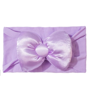 Nahaufnahme des lavendelfarbenen Strick-Baby-Stirnbands mit großer Satin-Schleife