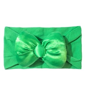 Detail eines Baby Stirnbands mit grüner Satinschleife und elastischem Strickgewebeband