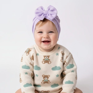 Détail du turban bébé en maille gaufrée lavande avec gros nœud porté par un nourrisson