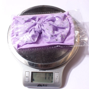 Détail d'un bandeau à nœud violet pesant 11,1 g sur une balance numérique emballée