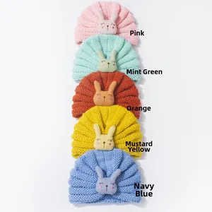 Detail view of five colored baby knit turban hats with 3D plush rabbit head decorations