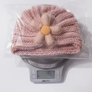 Detailed weight measurement showing 46.1g for the pink knit baby hat with flower detail