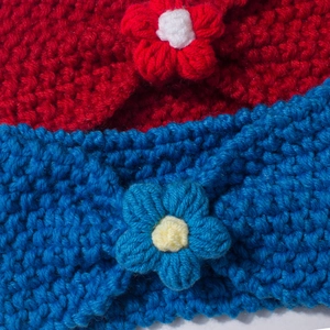 Close-up of knit baby headbands featuring red and blue 3D flowers and thick crochet texture