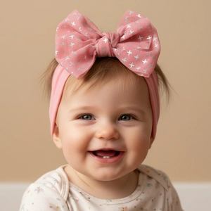 Bandeau bébé rose en nylon avec nœud en maille et étoiles argentées sur un modèle