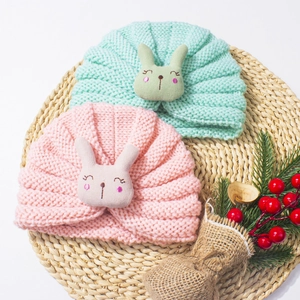 Detailed knit texture of pink and mint baby hats with cute 3D bunny rabbit embroidery