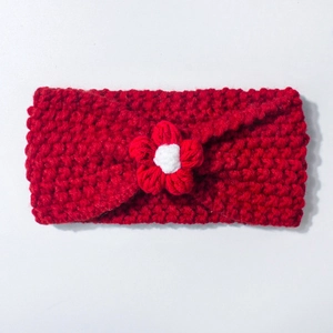 Close-up of red crochet knit baby headband with white flower detail and soft texture