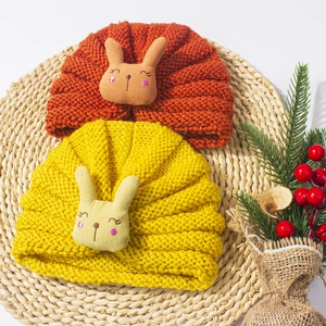 Close-up of knit baby hats with cute 3D bunny dolls and soft spiral texture