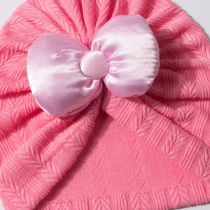 Gros plan d'un bonnet turban pour bébé en tricot à chevrons avec nœud en satin