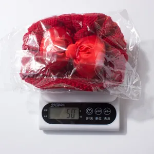 Détail du bonnet de bébé en tricot rouge de 50g avec un grand nœud en satin
