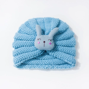 Detail of light blue baby knitted hat featuring a 3D grey bunny and ribbed texture