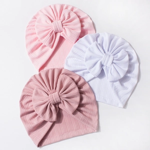 Infant waffle turban hats with oversized bows in pink and white knit fabric