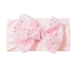 Gros plan sur un bandeau bébé rose avec grand nœud en mesh et motifs d'étoiles argent
