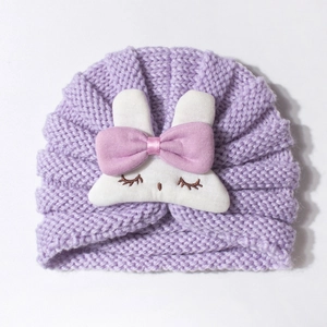 Purple knitted baby turban hat with a cute white rabbit doll and pink bow decoration
