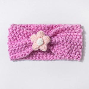 Detail of soft crochet baby headband featuring a bright pink knit and white flower
