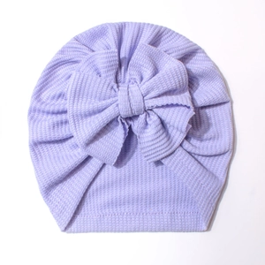 Détail du bonnet turban bébé violet lavande en tricot gaufré avec un grand nœud